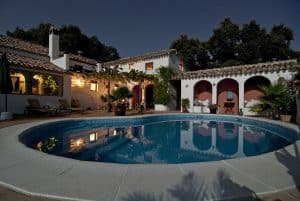 A designed lighting feature on the exterior wall is reflected in the pool