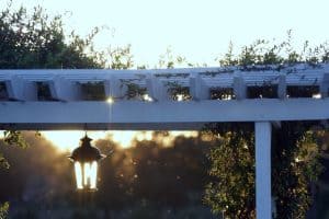 A light fixture hangs from a white trellis