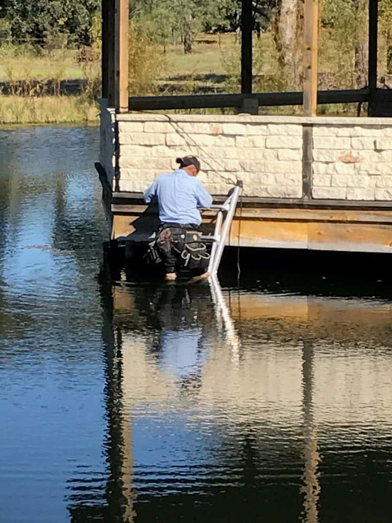 A Lighting Technician Installs wiring around a dock