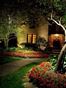 A DFW area home's landscaping is accented with red flowers