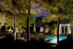 A Pool can be seen through a fence lit up at night