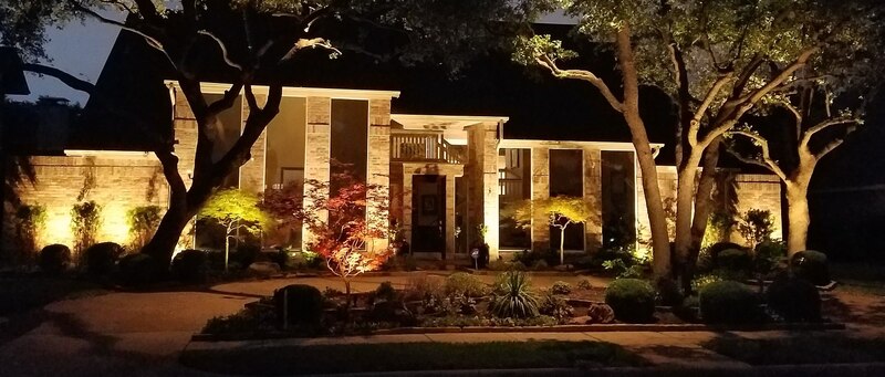 beautiful home lit up with outdoor lighting