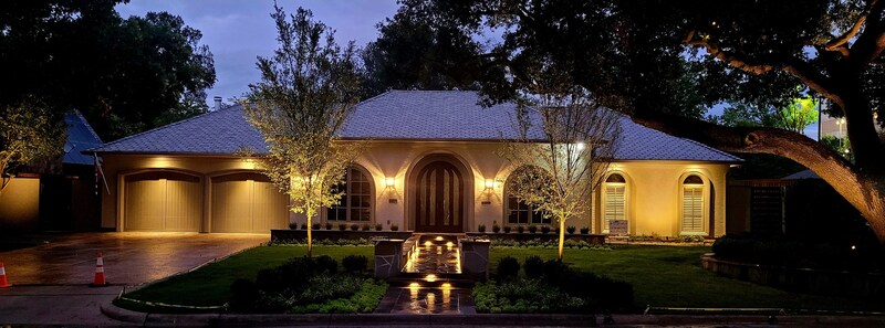 a beautiful home lit up by outdoor lighting