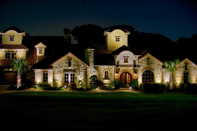 a beautiful house lit up by outdoor lighting