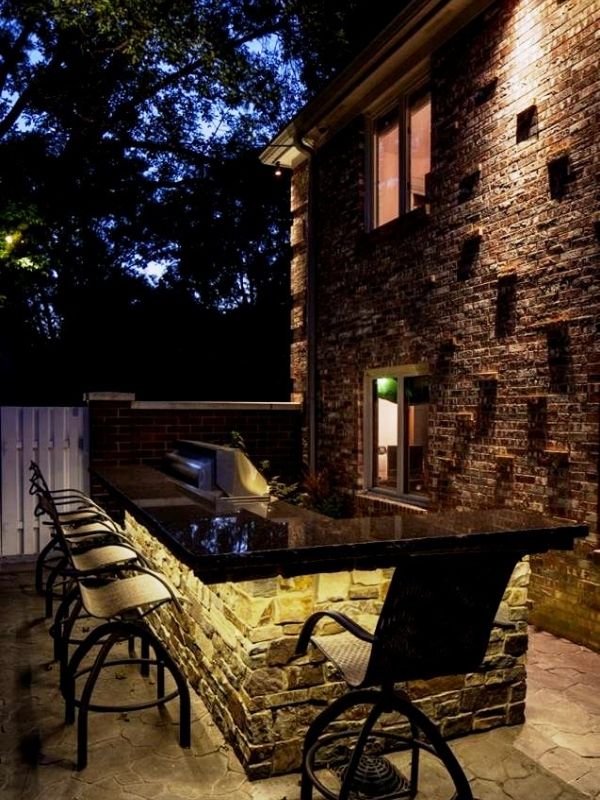 A beautiful outdoor kitchen illuminated by led lights. 