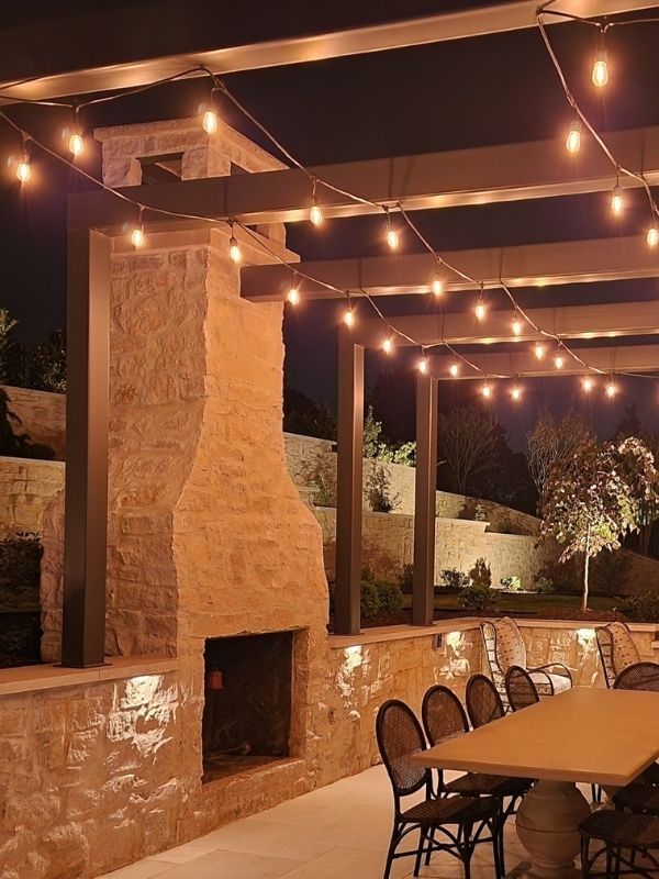 An outdoor dining area with an outdoor fireplace. 